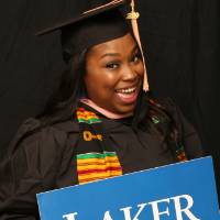 woman smiling with laker for a lifetime sign at GradFest photobooth